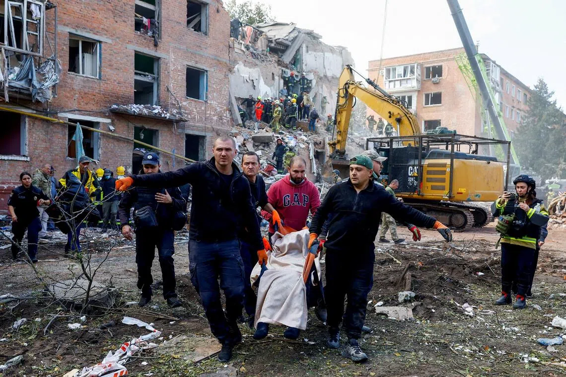 A casualty is carried away from the scene of a Russian missile strike in Pryluky, Ukraine, on Oct 7. Three of the 18 victims of the strike were just 12 months old, while another was aged eight.