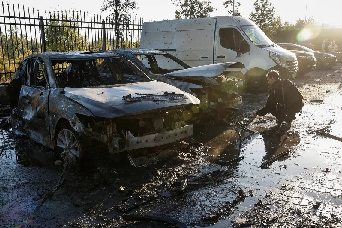 A police officer works near damaged vehicles at the site of a residential building damaged during a Russian drone and missile strike, amid Russia's attack on Ukraine, in the outskirts of Kyiv, Ukraine, September 20, 2025. REUTERS/Alina Smutko