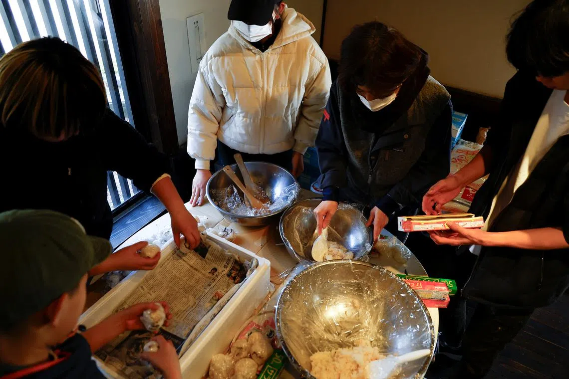 People preparing food to distribute among neighbours at a community kitchen organized by Shinto shrine priest Ayuko Noto, following the earthquake, in Wajima, Ishikawa Prefecture, Japan, Jan 6, 2024. 