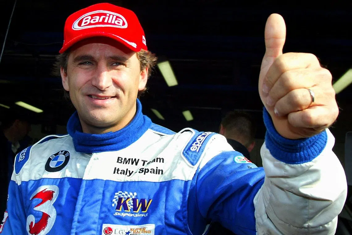 FILE PHOTO: Italian BMW 320i racing car driver Alex Zanardi gives a thumbs up before the start of an LG Super Racing car event at the Monza race track October 19, 2003. REUTERS/Giampiero Sposito  GS/File Photo