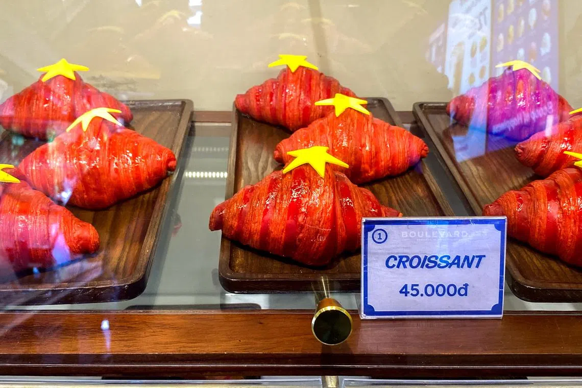 Red croissants decorated with yellow stars are displayed at a bakery shop in Hanoi, Vietnam, August 31, 2025. REUTERS/Francesco Guarascio