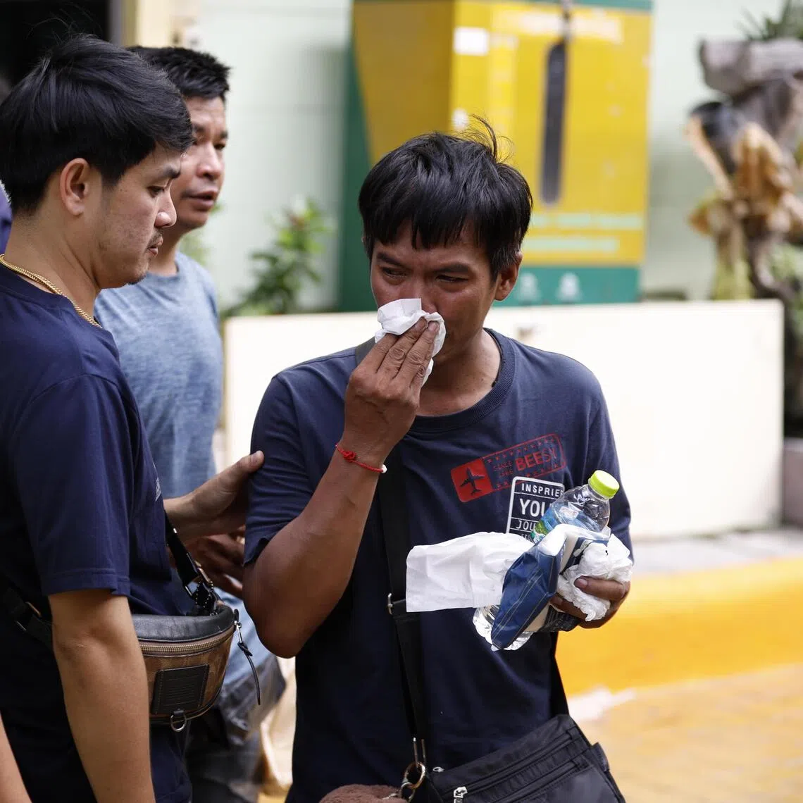 A relative (right) of a slain teacher cries after identifying the body at Debsirin Nonthaburi School in Bang Kruai district, Nonthaburi province, on Aug 7.