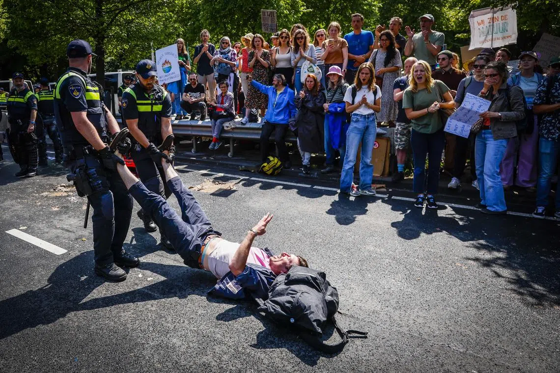 Police officers remove an Extinction Rebellion activist during a protest in The Hague.