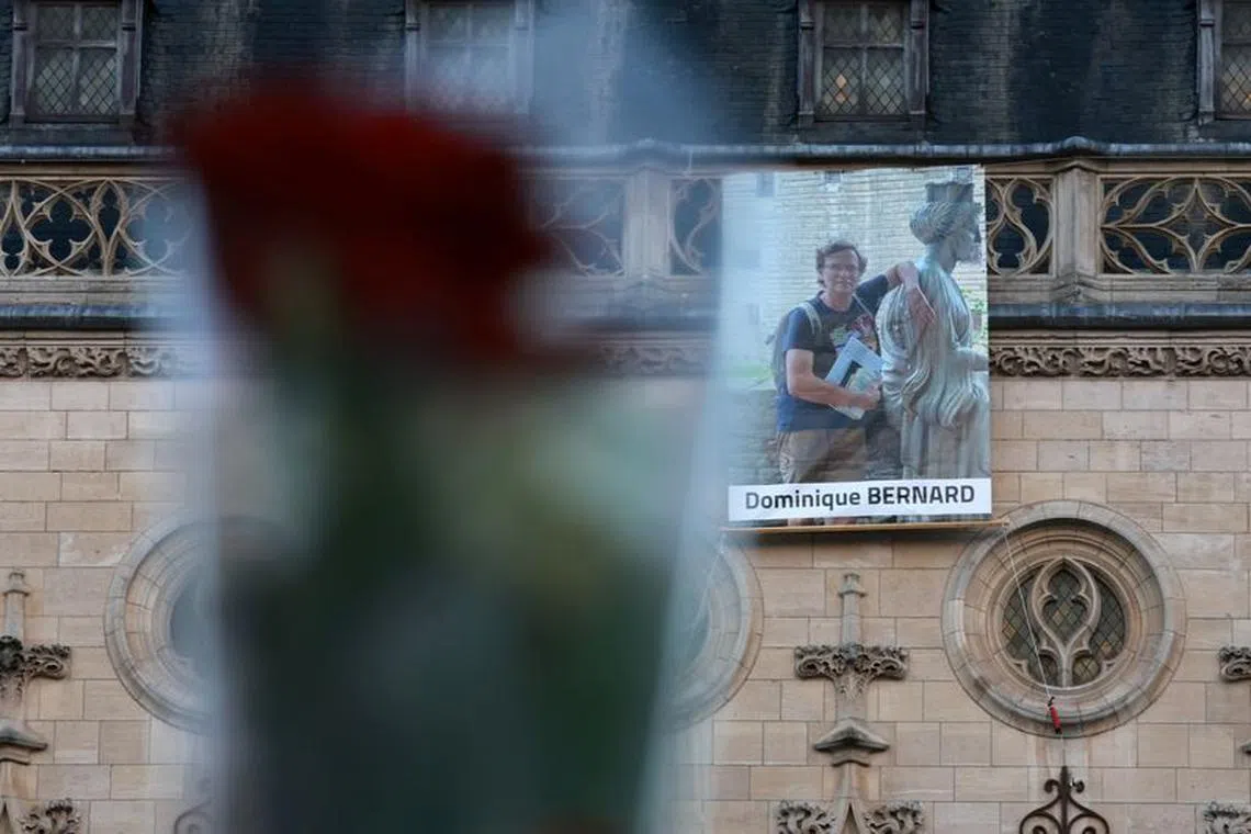 A portrait of French teacher Dominique Bernard, who was killed in a knife attack in a high school, hangs on the beffroi (belfry) of Arras city hall before the funeral ceremony at the Notre-Dame-et-Saint-Vaast Cathedral in Arras, northern France, October 19, 2023. REUTERS/Pascal Rossignol