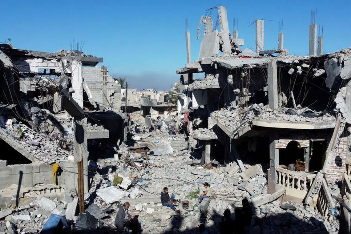 Palestinians cook among the houses destroyed in Israeli strikes during the conflict, amid the temporary truce between Israel and the Palestinian Islamist group Hamas, at Khan Younis refugee camp, in the southern Gaza Strip, November 29, 2023. REUTERS/Mohammed Salem/File Photo