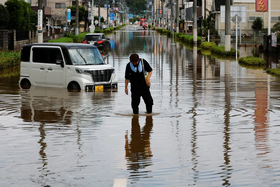 A local resident walks through a flooded street after Typhoon Dujuan brought torrential rain to Sakura, Chiba prefecture, Japan, September 22, 2026. REUTERS/Kim Kyung-Hoon