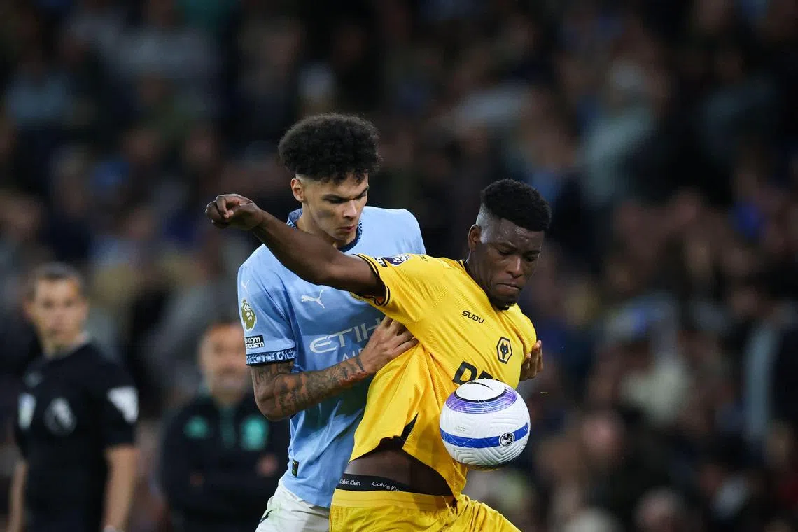 Manchester City's English midfielder #75 Nico O'Reilly (L) fights for the ball with Wolverhampton Wanderers' Zimbabwean midfielder #05 Marshall Munetsi during the English Premier League football match between Manchester City and Wolverhampton Wanderers at the Etihad Stadium in Manchester, north west England, on May 2, 2025. (Photo by Darren Staples / AFP) / RESTRICTED TO EDITORIAL USE. No use with unauthorized audio, video, data, fixture lists, club/league logos or 'live' services. Online in-match use limited to 120 images. An additional 40 images may be used in extra time. No video emulation. Social media in-match use limited to 120 images. An additional 40 images may be used in extra time. No use in betting publications, games or single club/league/player publications. / 