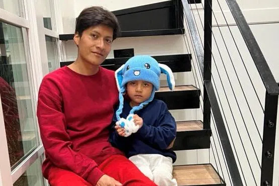 Liam Conejo Ramos and his father Adrian Alexander Conejo Arias sitting on the stairs back at their home after a judge ordered their release, in Columbia Heights, Minnesota, US.