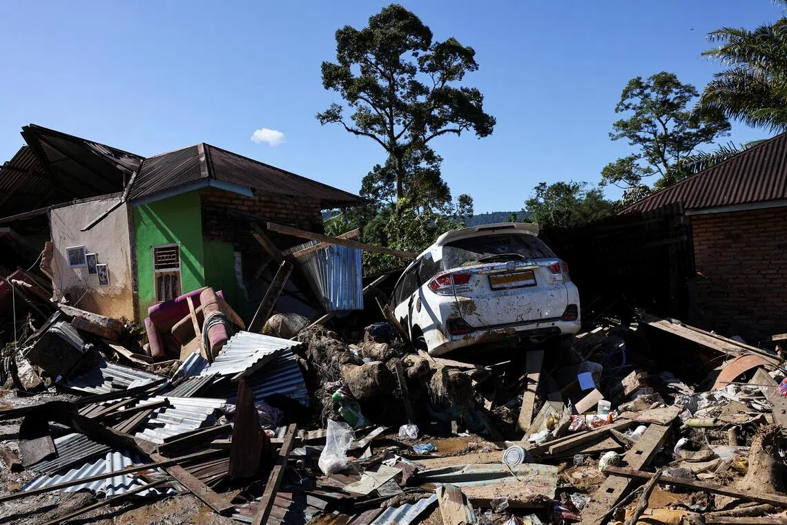 A car stuck among rubble at an area hit by deadly flash floods following heavy rains in Palembayan, West Sumatra.