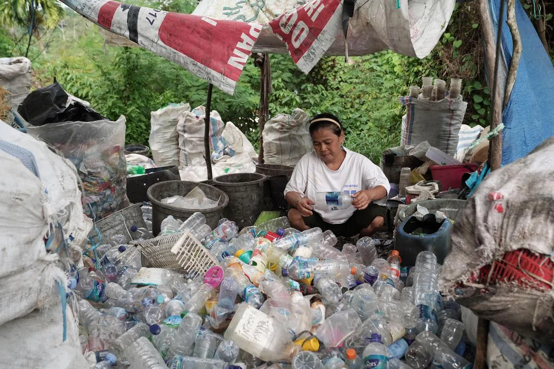 A woman sorts out plastic bottles for recycling at a plastic garbage collection area at the port city of Balikpapan in East Kalimantan, Borneo, Indonesia.