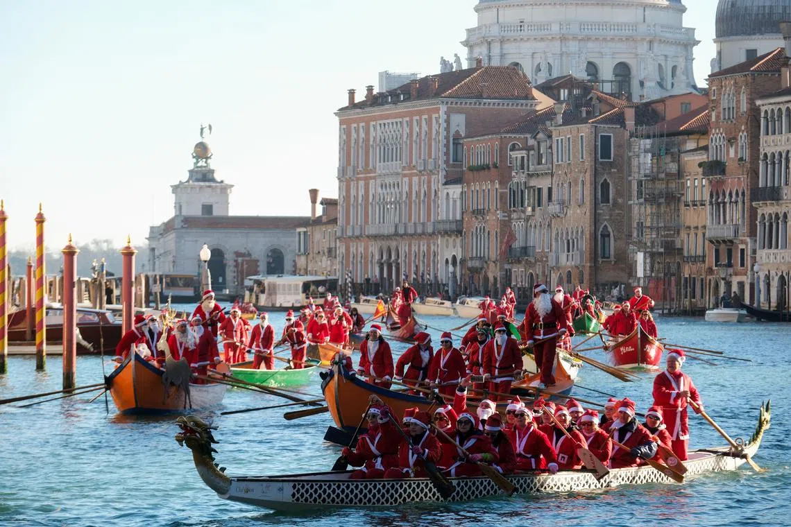Santas rowing along the Grand Canal in Venice, Italy, during a Christmas regatta on Dec 17, 2023.