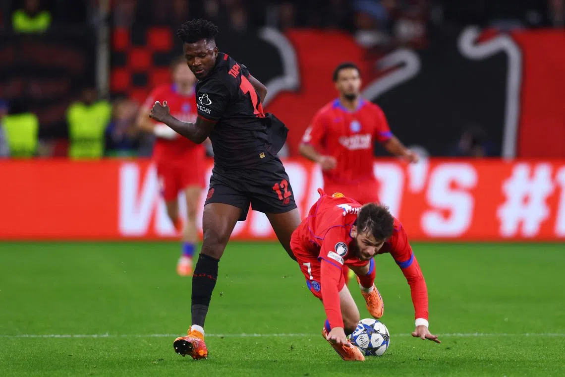FILE PHOTO: Soccer Football - UEFA Champions League - Bayer Leverkusen v Paris St Germain - BayArena, Leverkusen, Germany - October 21, 2025 Bayer Leverkusen's Edmond Tapsoba in action with Paris St Germain's Khvicha Kvaratskhelia REUTERS/Thilo Schmuelgen/ File Photo