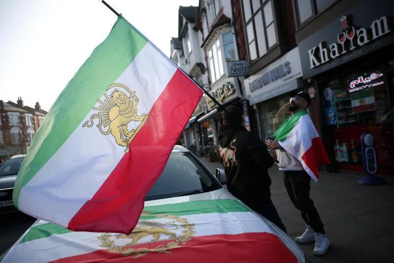 Iranian men hold pre-Iranian Revolution "Lion and Sun" flags in Finchley, an area home to a large Iranian community, in London, Britain.