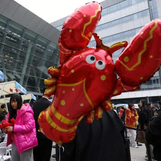 Participants lining up near a lobster-shaped balloon to install OpenClaw, an open-source AI agent, outside the Baidu offices in Beijing earlier this year.