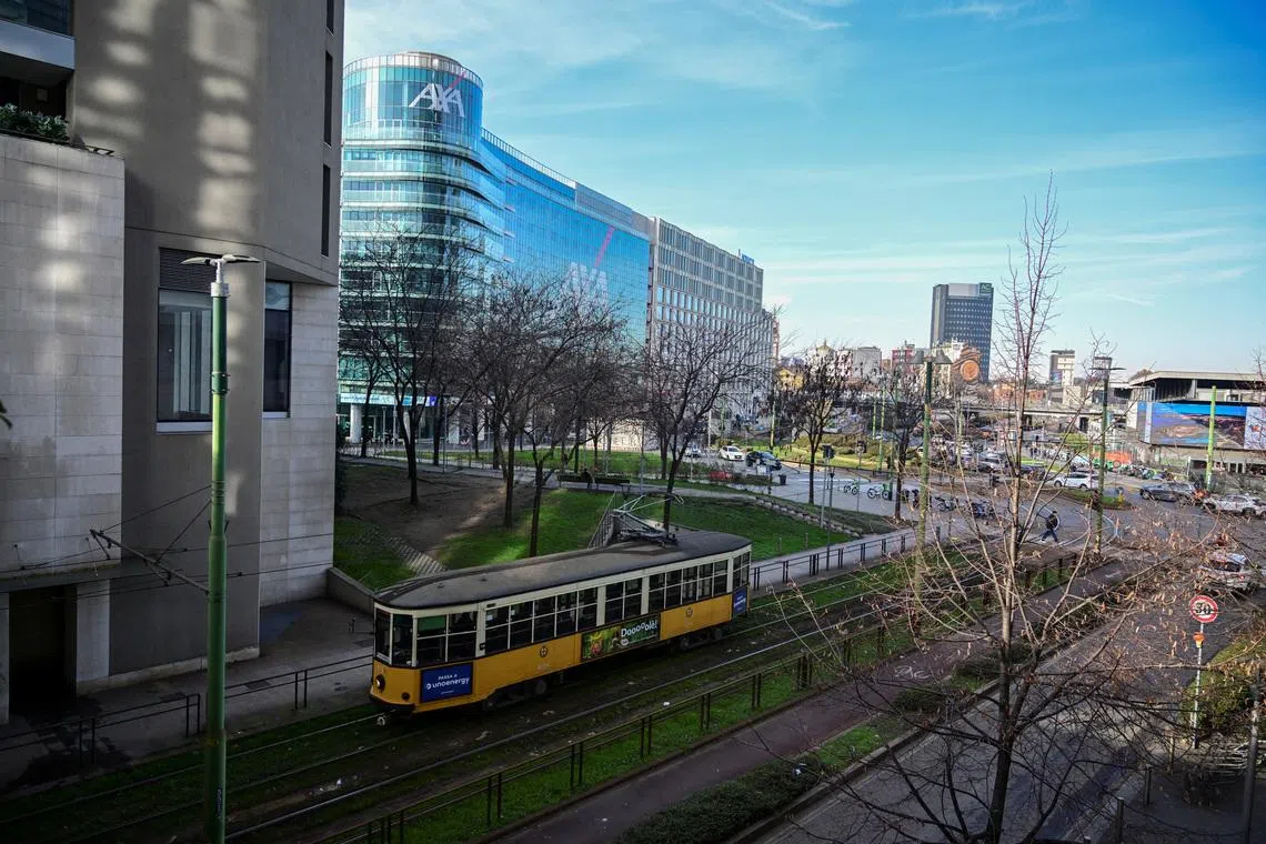A historic tram travels along a street lined with modern office buildings in Milan, Italy, January 5, 2026. REUTERS/Daniele Mascolo