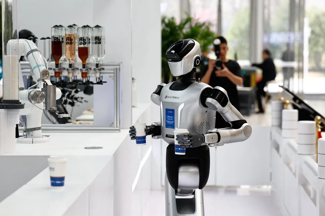 A humanoid robot by Leju Robotics fetching cups of coffee in a demonstration at the 2026 Zhongguancun forum in Beijing on March 25.