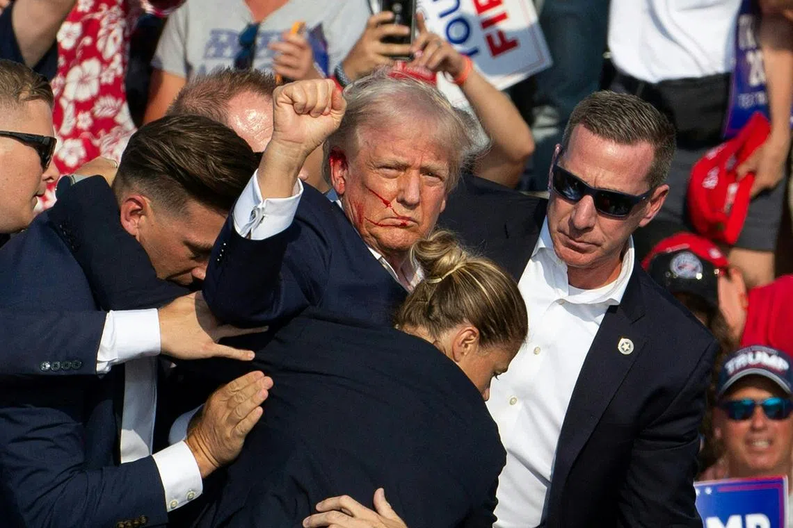 Donald Trump surrounded by secret service agents as he is taken off the stage at a campaign event at Butler Farm Show Inc. in Butler, Pennsylvania, on July 13, 2024.