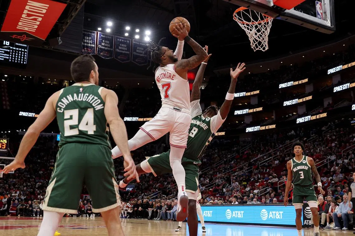 Houston Rockets' Cam Whitmore attemping a shot while the Milwaukee Bucks' Bobby Portis tries to stop him.