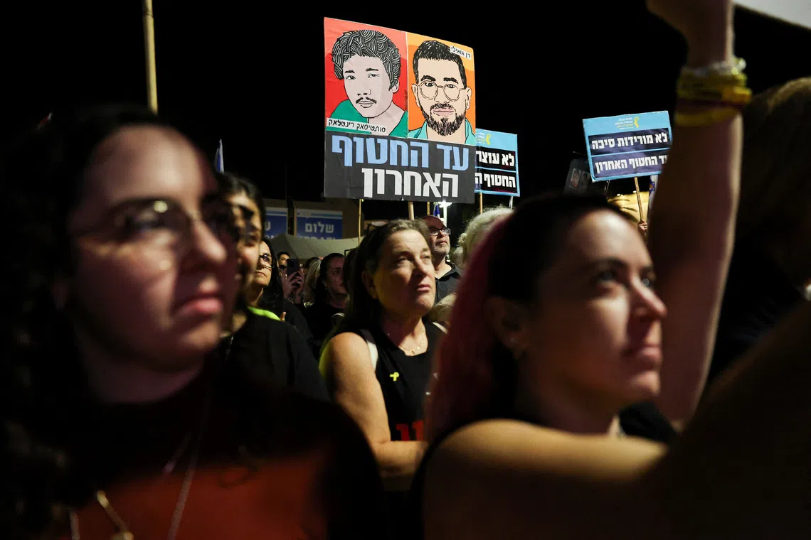 People hold images of dead hostages Ran Gvili and Sudthisak Rinthalak, whose bodies haven’t been returned yet, as Israelis attend a rally calling for the immediate return of the remains of all hostages held in Gaza, more than two years after the deadly October 7, 2023, attack on Israel by Hamas, at the Hostages Square in Tel Aviv, Israel, November 29, 2025. REUTERS/Nir Elias