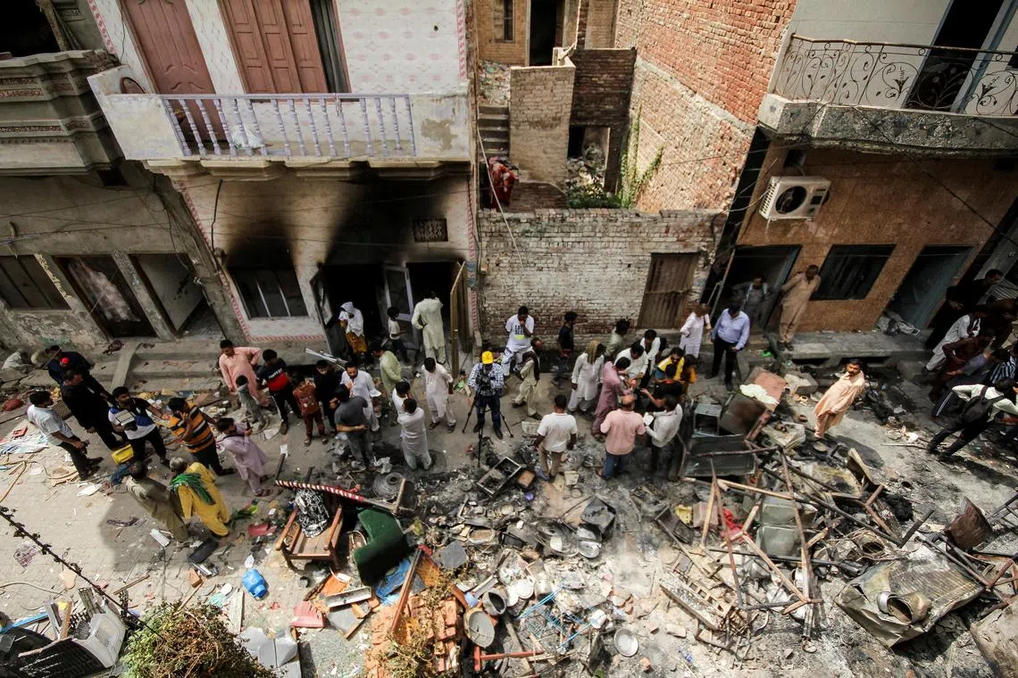 FILE PHOTO: People and members of the media gather along a street in a Christian neighbourhood, a day after the church buildings and houses were vandalised by protesters in Jaranwala, Pakistan August 17, 2023. REUTERS/Muhammad Tahir/File Photo NO RESALES. NO ARCHIVES.