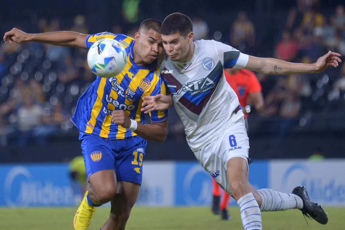 Sportivo Luqueno's Marcelo Perez and Godoy Cruz's Leandro Quiroz fighting for the ball during the Copa Sudamericana group stage football match, at the Defensores del Chaco stadium in Asuncion, on May 6, 2025. 