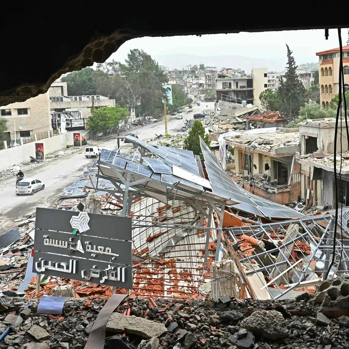 Displaced residents drive past destroyed buildings as they return to the southern Lebanese city of Nabatieh on April 18 amid the ceasefire in the Israel-Hezbollah war.