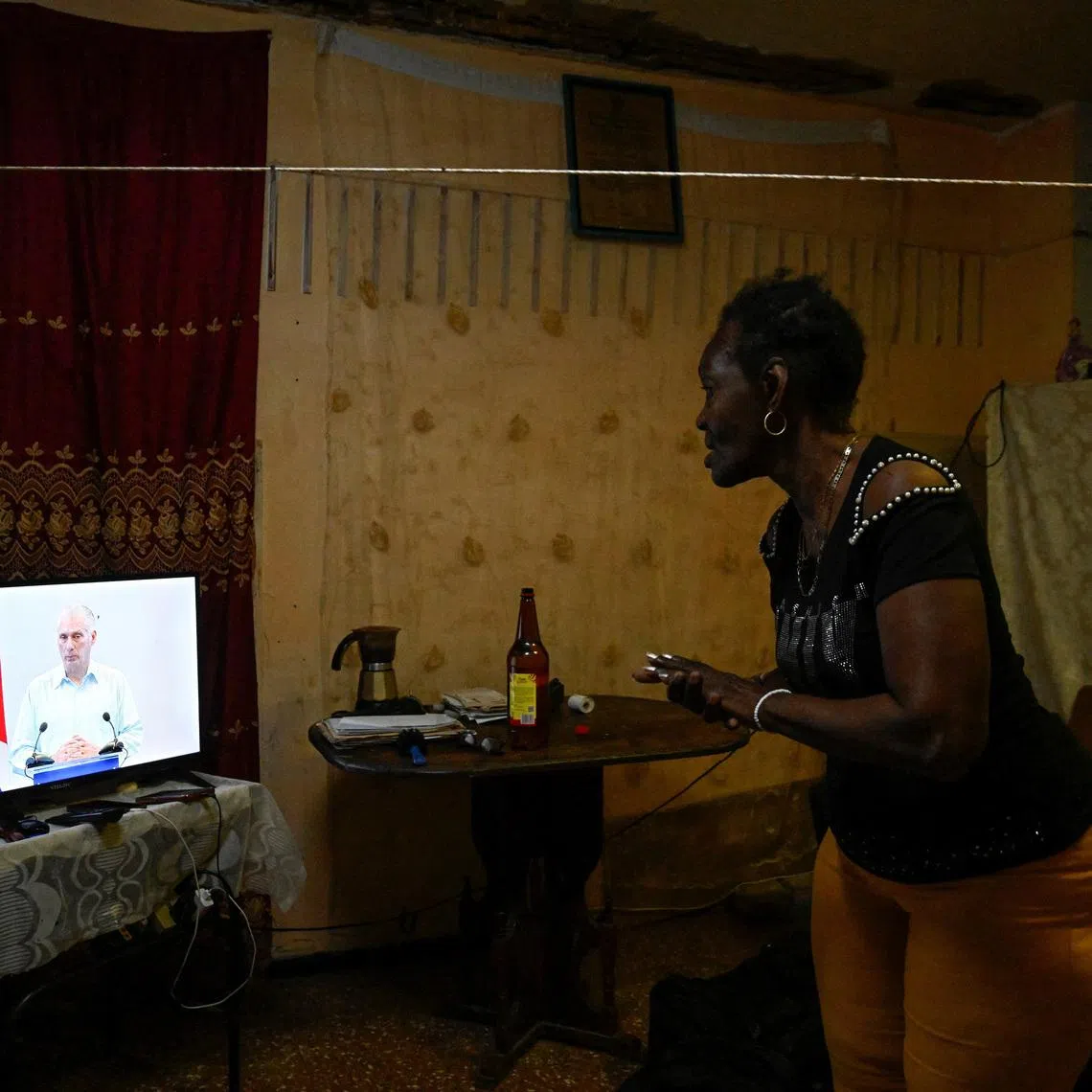 Teresa Rodriguez, 58, looks at Cuba's President Miguel Diaz-Canel on state television, as Diaz-Canel said the country has opened talks with the U.S. government amid a severe economic crisis and as the Communist government has come under increasing pressure from U.S. President Donald Trump, in Havana, Cuba March 13, 2026. REUTERS/Norlys Perez