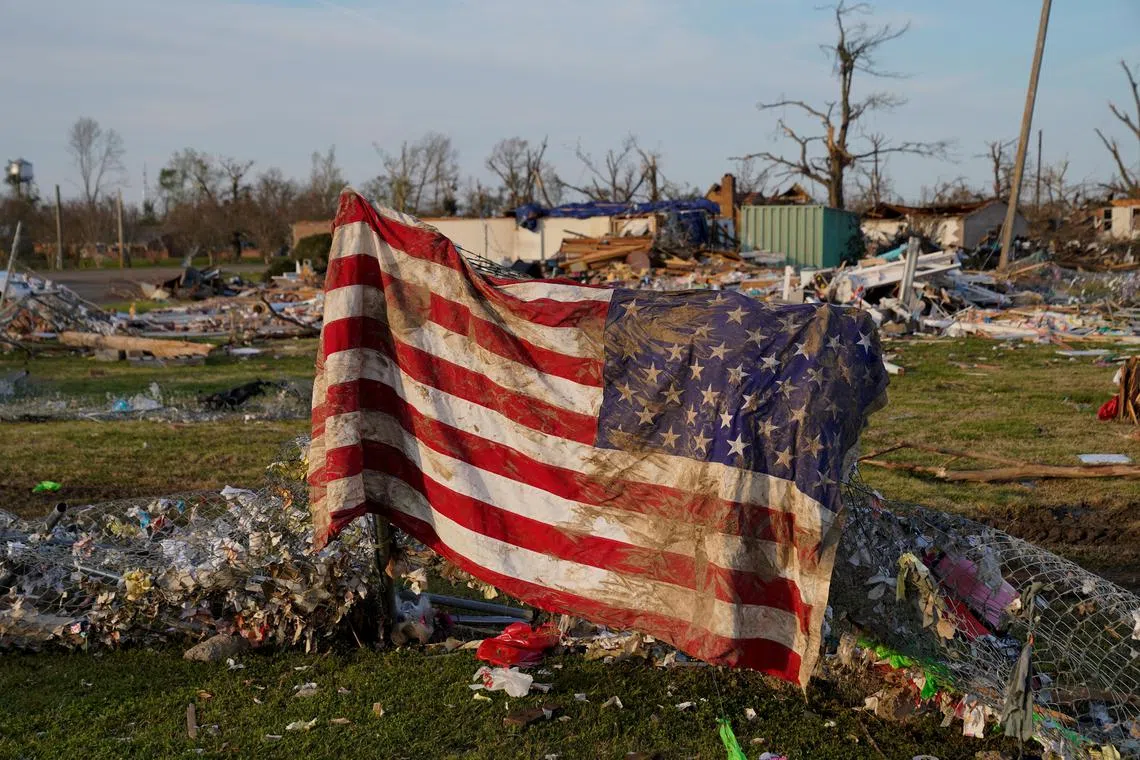 A muddied American flag is seen draped over wreckage after thunderstorms spawning high straight-line winds and tornadoes ripped across the state, in Rolling Fork, Mississippi, U.S., March 26.