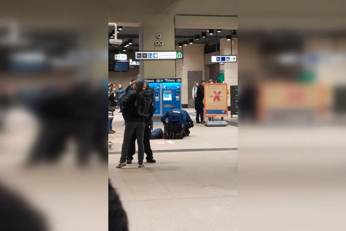 Police detain a man after a knife attack in Brussels' Schuman metro station.
