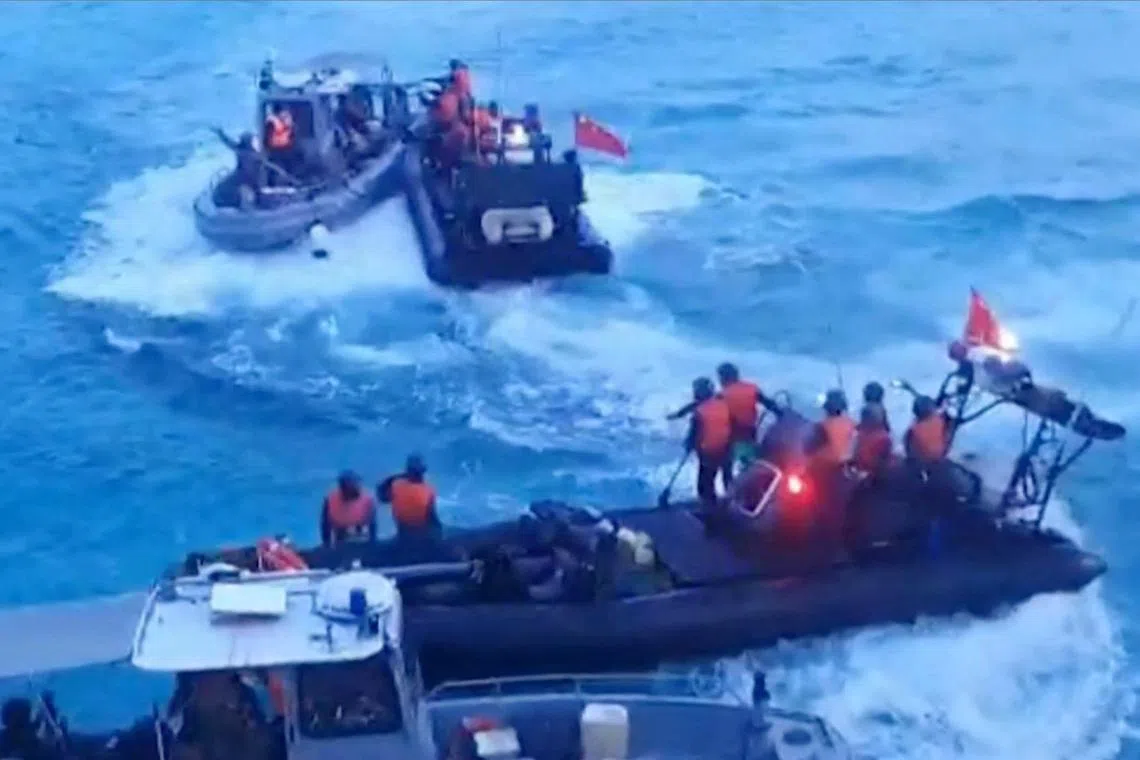 (FILES) This frame grab from handout video footage taken on June 17, 2024 and released on June 25 by the Armed Forces of the Philippines shows Chinese Coast Guard personnel aboard rigid hull inflatable boats (in black) during a confrontation with Philippine Navy personnel on their respective vessels (in gray) near the Second Thomas Shoal in disputed waters of the South China Sea. The Philippines and China agreed on July 2, 2024 to "de-escalate tensions" over the South China Sea, Manila said, following a violent clash in the disputed waters. (Photo by Handout / ARMED FORCES OF THE PHILIPPINES / AFP) / RESTRICTED TO EDITORIAL USE - MANDATORY CREDIT "AFP PHOTO / ARMED FORCES OF THE PHILIPPINES" - NO MARKETING NO ADVERTISING CAMPAIGNS - DISTRIBUTED AS A SERVICE TO CLIENTS