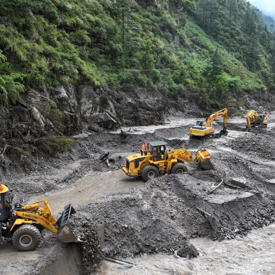 Rescue workers repair a road leading to Gyirong Port after a mudslide, in Gyirong county, in Tibet, on Aug 28.