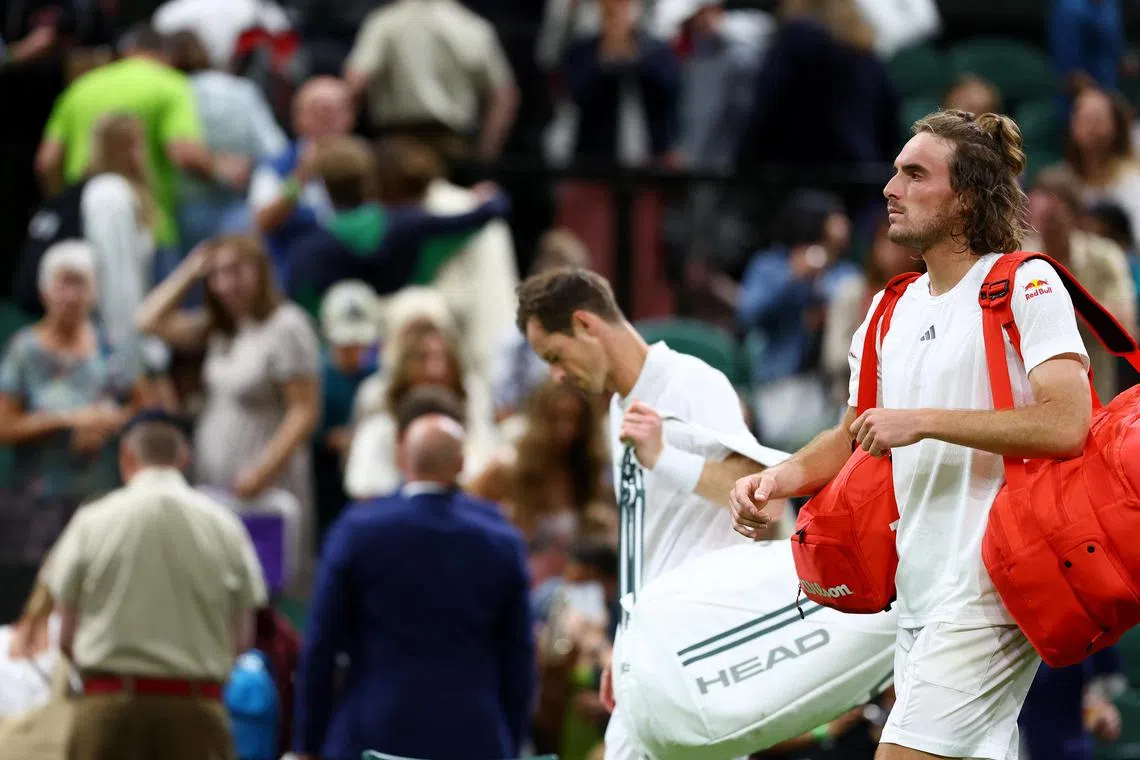 Britain’s Andy Murray (left) and Greece's Stefanos Tsitsipas leave the court after their second-round match is suspended.