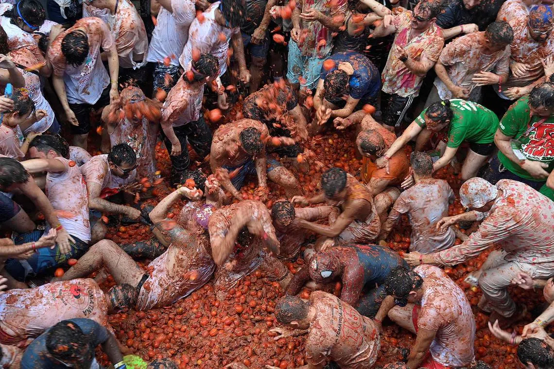 Revellers taking part in the Tomatina, an annual food battle where people hurl tomatoes at each other, in the Spanish eastern town of Bunol, on Aug 28, 2024. 