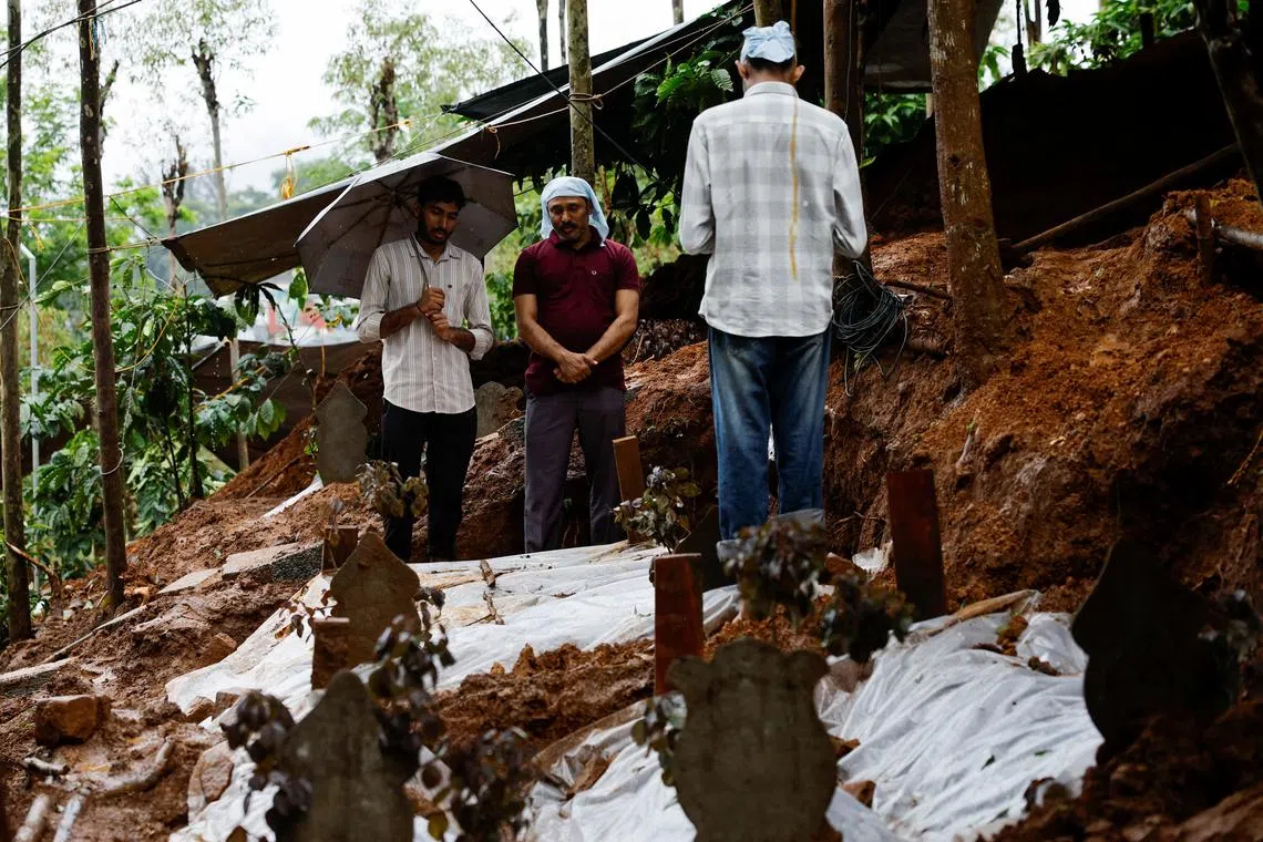 People pray for a departed family member at their grave at a graveyard, after landslides hit several villages in Wayanad district, in Meppadi, in the southern state of Kerala, India, August 2, 2024. REUTERS/Francis Mascarenhas