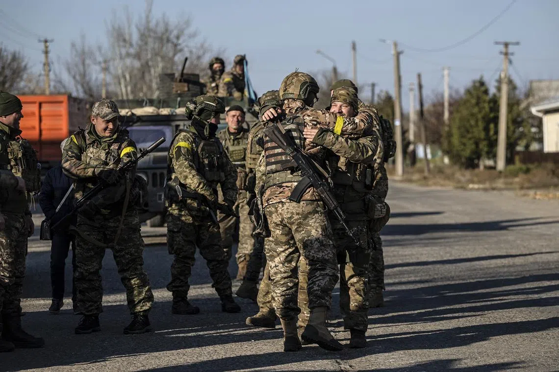 Ukrainian soldiers embrace as they celebrate liberation from Russian occupation along the Kherson front on Nov 10, 2022.