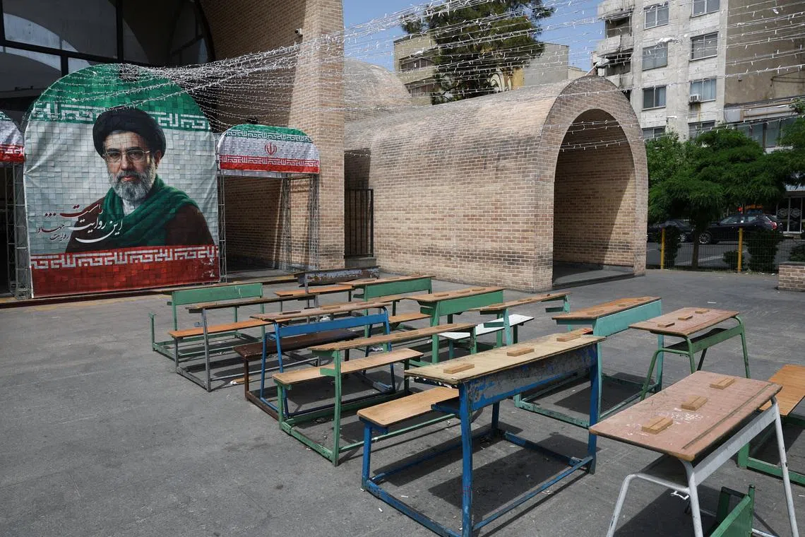A banner with a picture of Iran's new Supreme Leader Mojtaba Khamenei next to a symbolic classroom of the Minab school students who were killed in a strike, in Tehran, Iran.