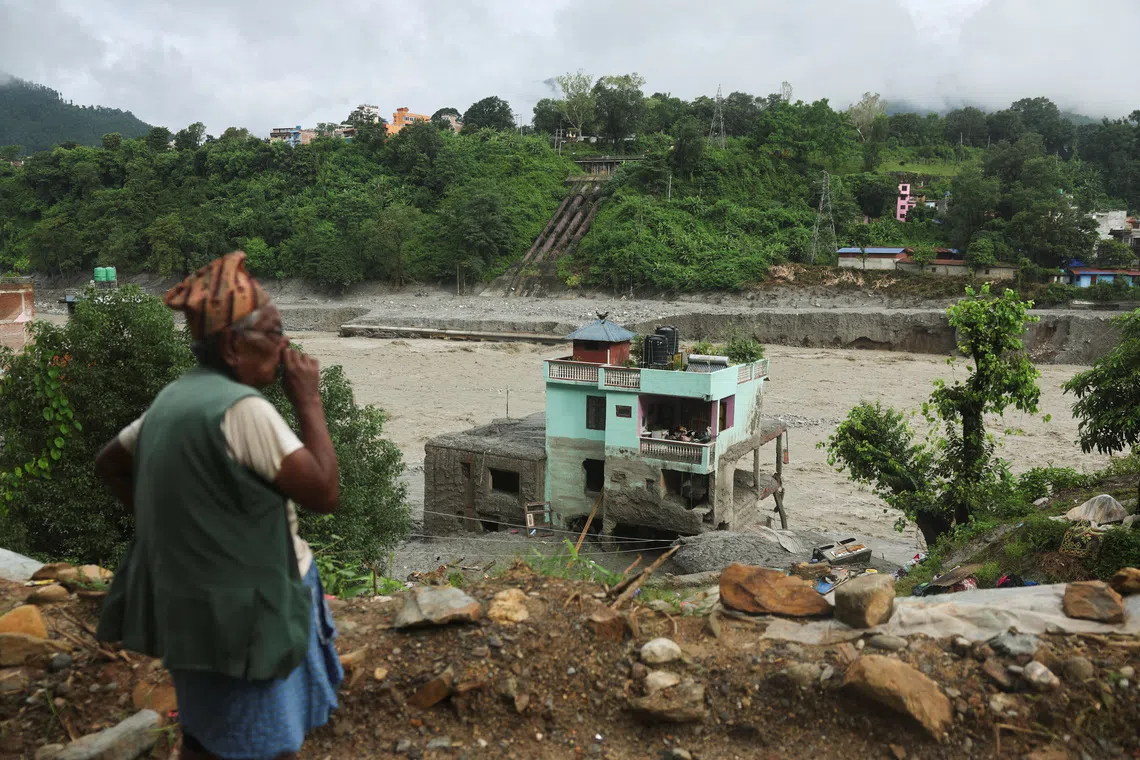 A man looks at the "green miracle house" as it stands amid debris after surviving flash floods and a mudslide in Trishuli, Nuwakot district, Nepal, September 1, 2026. REUTERS/Francis Mascarenhas