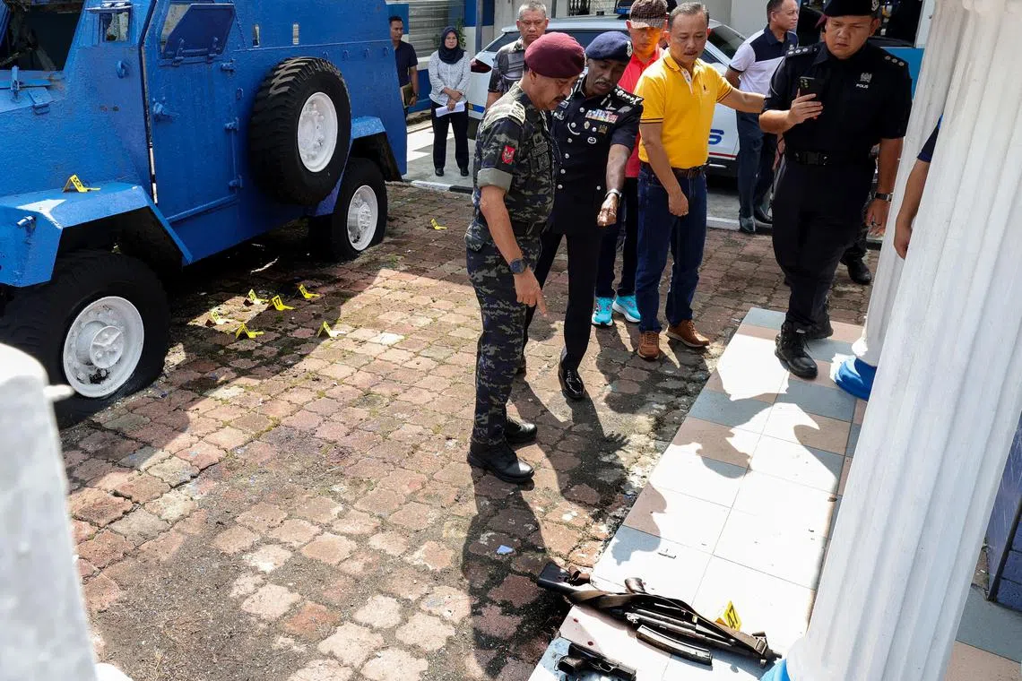 Malaysia's Inspector-General of Police Razarudin Husain (left) and Johor police chief M. Kumar inspecting the scene at the Ulu Tiram Police Station on May 17.