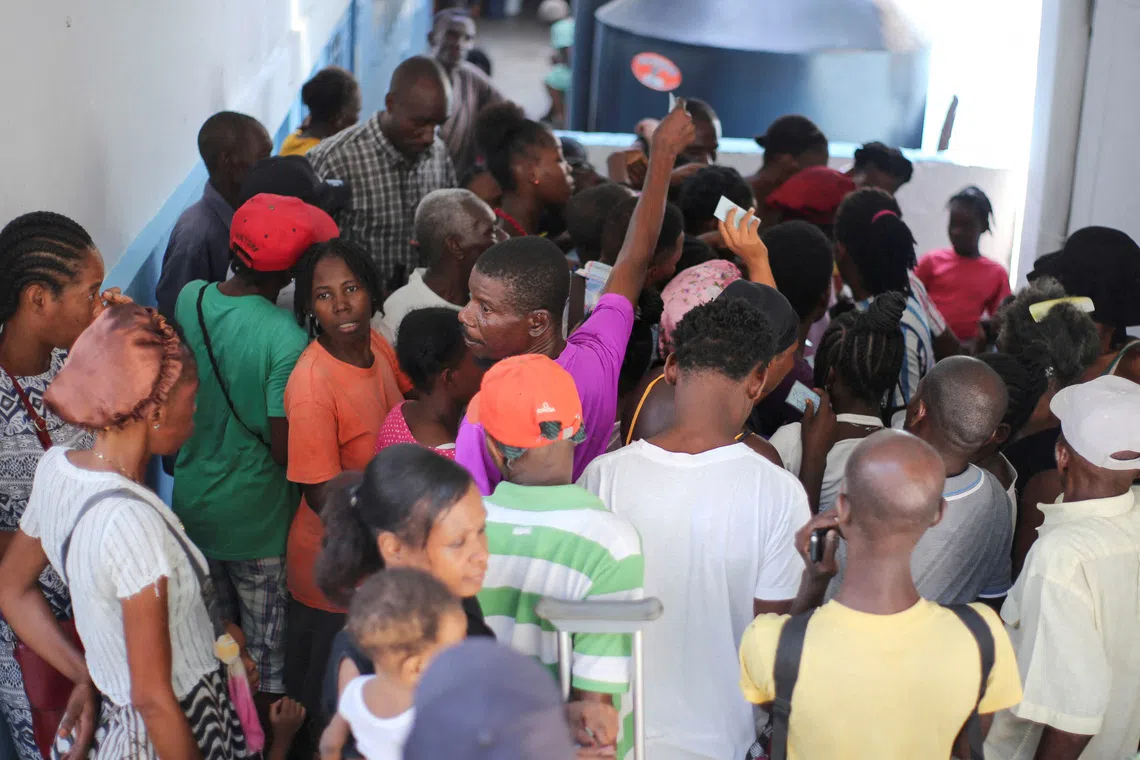FILE PHOTO: People gather to receive food at the temporary shelter in College des Antilles as the country faces emergency food insecurity while immersed in a social and political crisis, in Port-au-Prince, Haiti October 4, 2024. REUTERS/Jean Feguens Regala/File Photo
