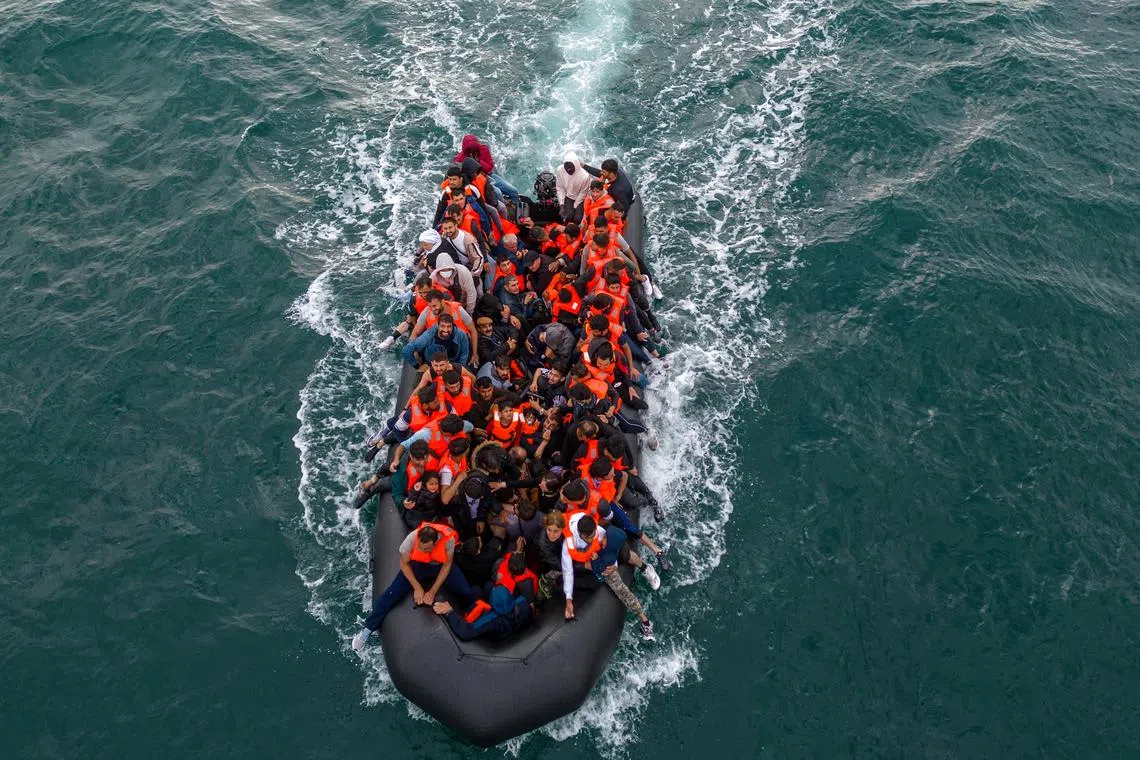 FILE PHOTO: In this drone view an inflatable dinghy carrying migrants makes its way towards England in the English Channel, Britain, August 6, 2024. REUTERS/Chris J. Ratcliffe/File Photo