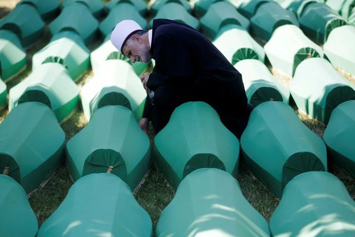 FILE PHOTO: Muslim effendi sits near coffins of his relatives, who are newly identified victims of the 1995 Srebrenica massacre, which are lined up for a joint burial in Potocari near Srebrenica, Bosnia and Herzegovina July 11, 2016. REUTERS/Dado Ruvic/File Photo
