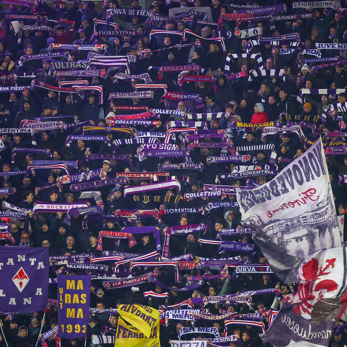 Fiorentina supporters hold up scarves in the stands during a Serie A match, in Florence, Italy, March 22, 2026. REUTERS/Guglielmo Mangiapane