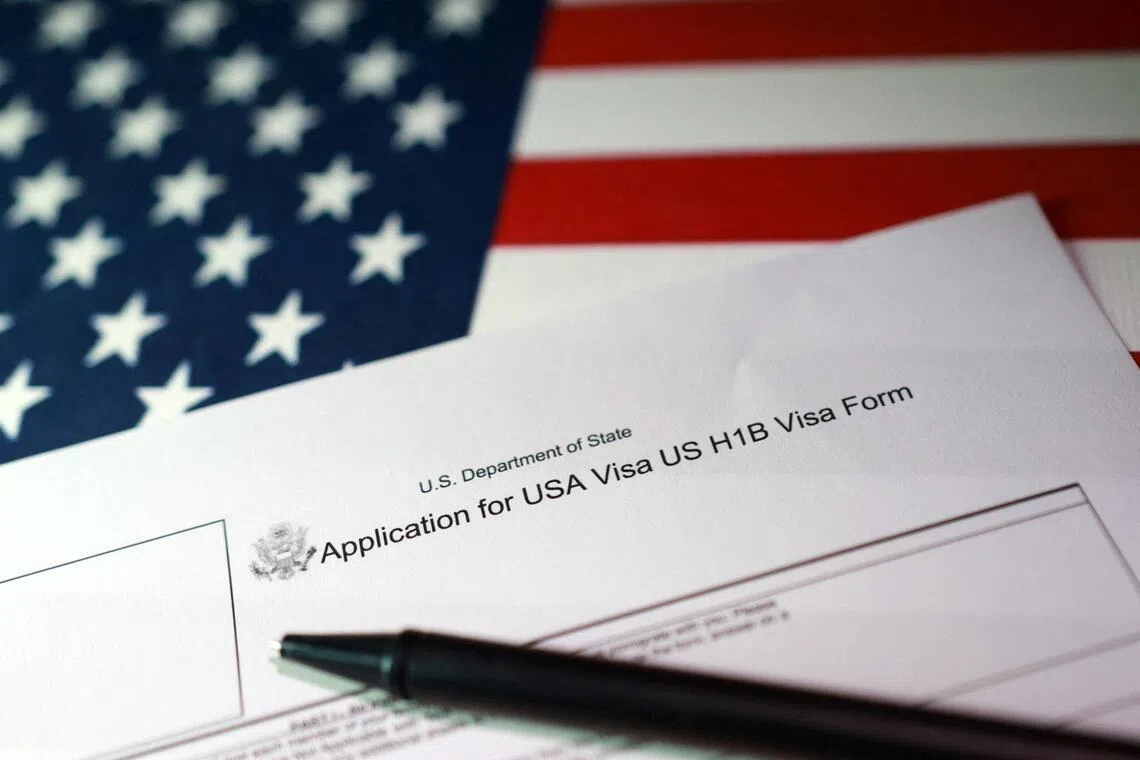 A US flag and a H-1B Visa application form are seen in this illustration taken Sept 22, 2025. PHOTO: REUTERS