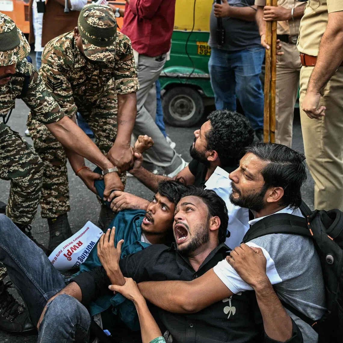 Security personnel detaining demonstrators during a protest in New Delhi on Oct 11.