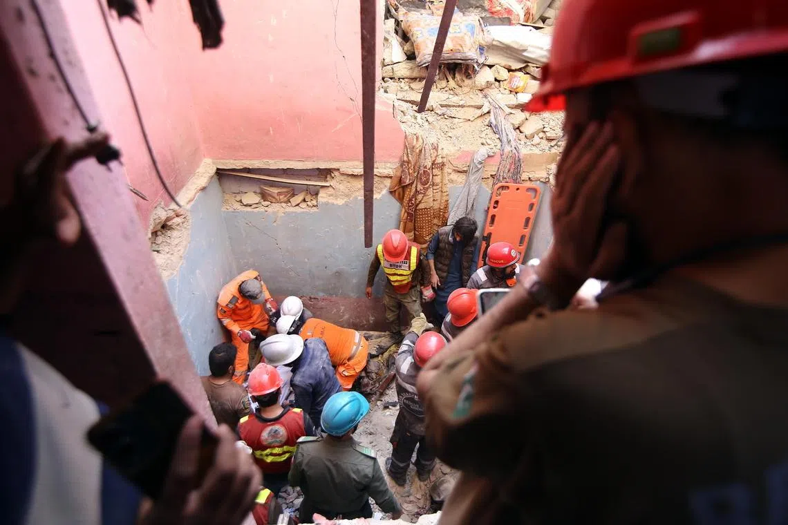 Rescue workers recover the bodies of the victims after a suspected gas explosion caused part of a residential building to collapse in Karachi, Pakistan.