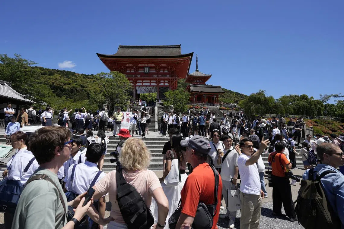 Tourists gather before Kiyomizudera temple, a famous tourist destination near Gion district, in Kyoto, on May 29.