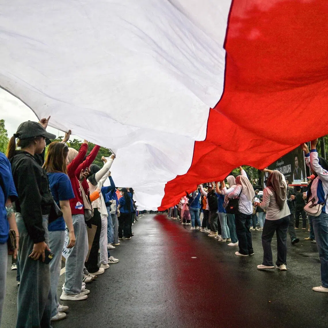 Indonesian workers unfurl the Indonesian flag during a May Day rally in front of the East Java Governor’s Office in Surabaya on May 1. 
