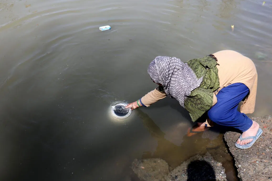 A Kashmiri woman filling a pot with water from a river in the village of Pattan, some 22 km north of Srinagar, Kashmir, India, March 18, 2024. Five villages have not had a reliable potable water supply for the past 25 years, only receiving a two-hour water supply on alternate days.