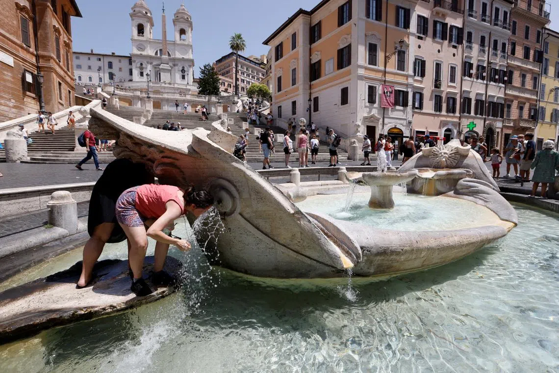 People cooling off near the Spanish Steps, during a heatwave across Italy, in Rome on July 18, 2023. 