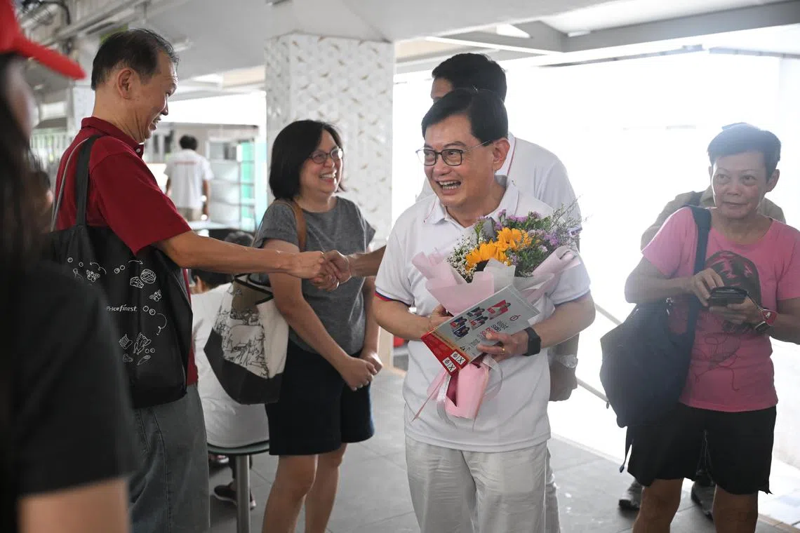 Deputy Prime Minister Heng Swee Keat with a bouquet given to him by a couple to thank him for all he had done, while on a walkabout in Bedok on May 1. 